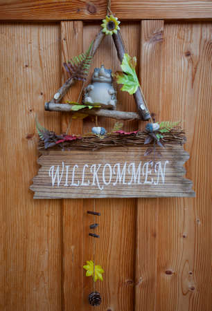 cute Wilkommen (welcome) in German on wooden hanging signの写真素材