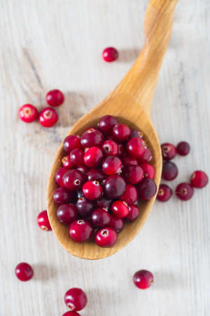 fresh cranberries on white wooden surfaceの写真素材