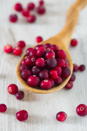 fresh cranberries on white wooden surfaceの写真素材