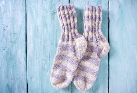 knitted socks on turquoise wooden surfaceの写真素材