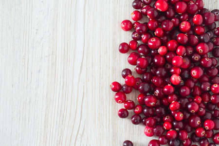 fresh cranberries on white wooden surface