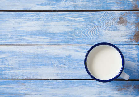 cup of milk on blue wooden surfaceの写真素材