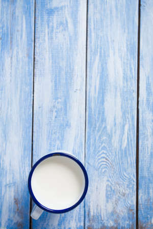 cup of milk on blue wooden surfaceの写真素材