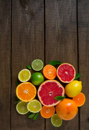 mixed citrus fruits on dark wooden backgroundの写真素材