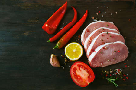 sliced raw meat and vegetables on wooden surfaceの写真素材