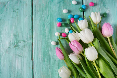 tulips and easter candies on wooden surfaceの写真素材