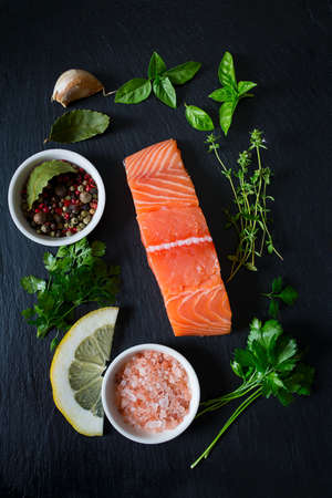 fresh salmon fillet on black stone surfaceの写真素材
