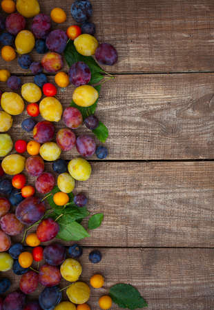 variety of plums on wooden surfaceの写真素材