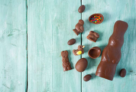 Easter composition with chocolate eggs and animals on wooden surface