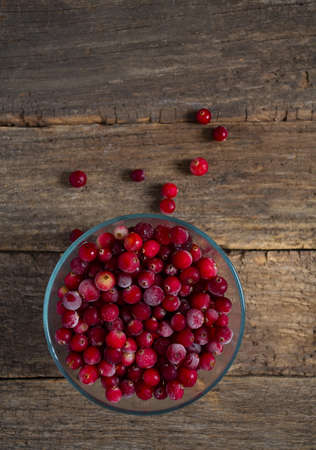 Frozen cranberries on wooden surface