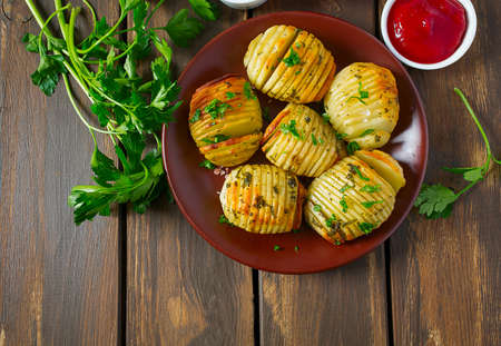 Hasselback potatoes on wooden surfaceの写真素材