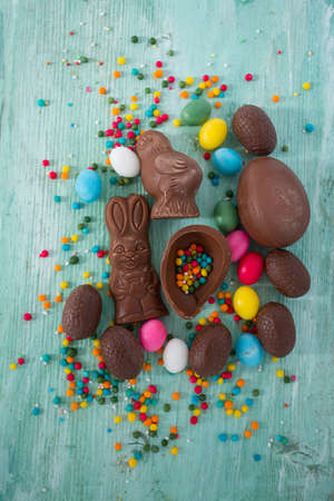 Easter composition with chocolate eggs and animals on wooden surface