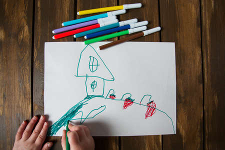 Kid drawing on wooden tableの写真素材