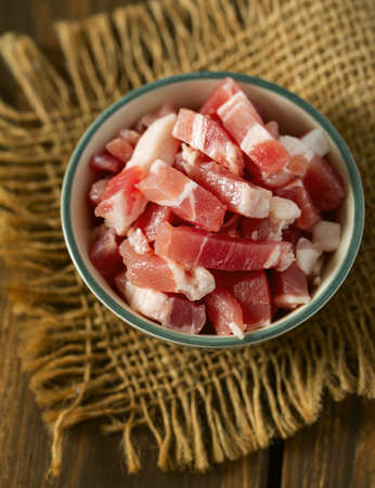 bacon cubes on wooden surfaceの写真素材