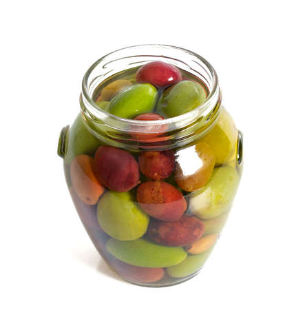 Pickled olives in a glass jar isolated on whiteの写真素材