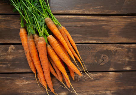 fresh carrots on wooden surface