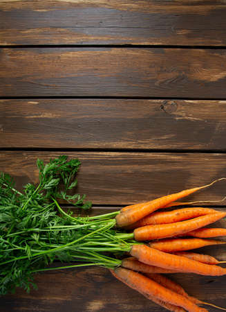 fresh carrots on wooden surface