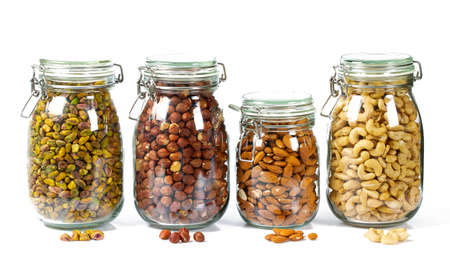 nuts in glass jars isolated on whiteの写真素材