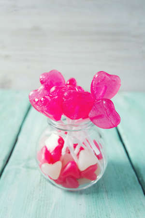heart-shaped candies on turquoise wooden surface