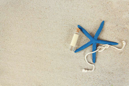 message in a bottle, sea shells and pebbles on sand