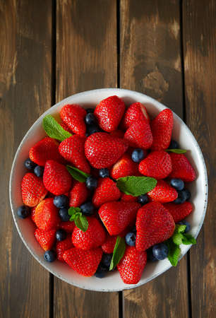 fresh strawberries on a dark wooden surfaceの写真素材