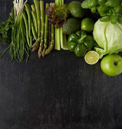 green vegetables and herbs on black chalkboardの写真素材