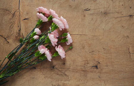 beautiful carnations on dark wooden surface