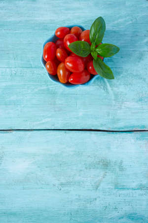 variety of miniature tomatoes on turquoise wooden surfaceの写真素材