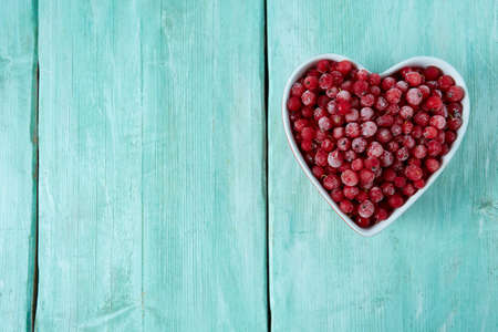 frozen red currants on wooden surfaceの写真素材