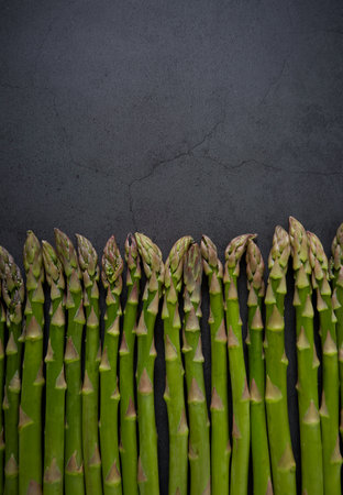 freh asparagus on dark stone surfaceの写真素材
