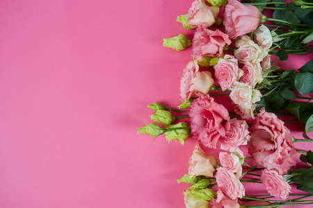 pink eustoma and rose flowers on pink surfaceの写真素材