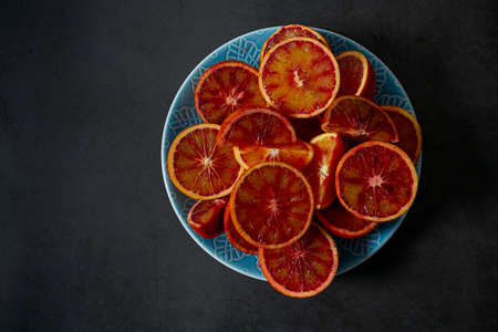 blood oranges on dark stone surface