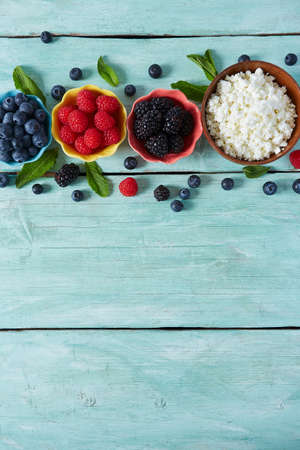 cotage cheese and fresh berries on turquoise surface