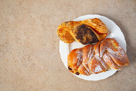 fresh sweet buns on a plate on granite surfaceの写真素材