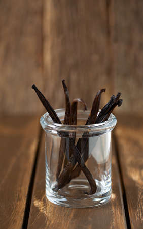vanilla pods in a glass jar on a wooden background. selective focusの写真素材