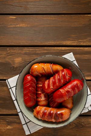 grilled sausages on wooden surface, top view,