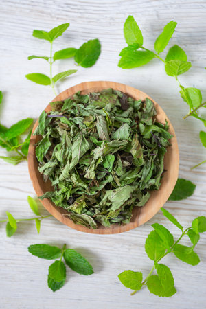 Dried mint leafs on wooden surface. Herbs and spices. Top view.