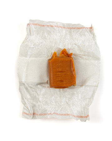 Soft caramel candies. Butterscotch toffee pieces isolated on white background. Top view.の写真素材