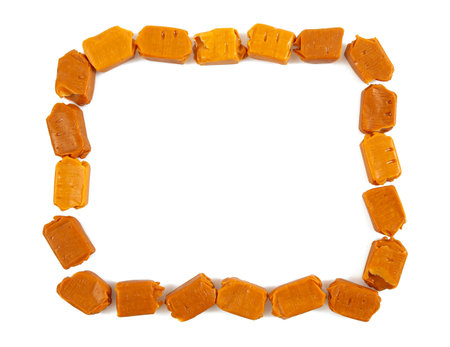 Soft caramel candies. Butterscotch toffee pieces isolated on white background.の写真素材