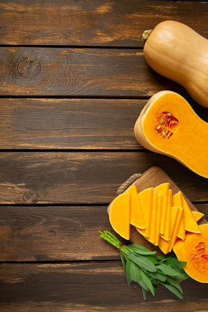 Fresh butternut squash with thyme and sage on a wooden surface.  Butternut Pumpkin . Healthy food concept. Top view and empty space for your text.の写真素材