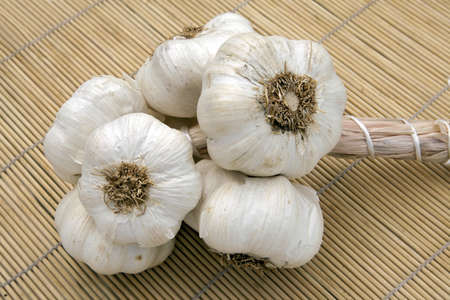 Braided garlic on bamboo placematの写真素材