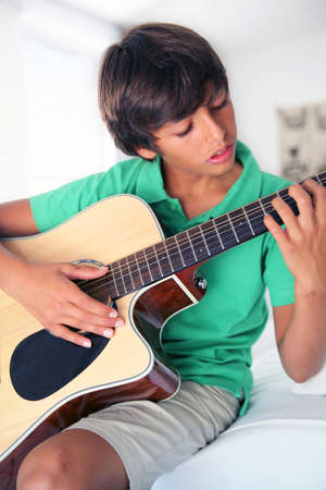 Boy learning to play guitarの写真素材