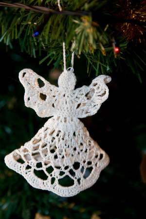 Little white handmade angel hanging on Christmas-treeの写真素材