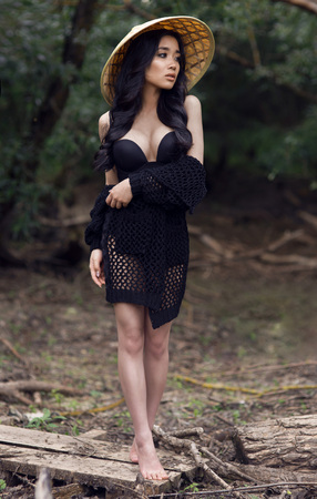 young sexy Vietnamese girl in a straw hat in a tropical forest. asian girlの写真素材