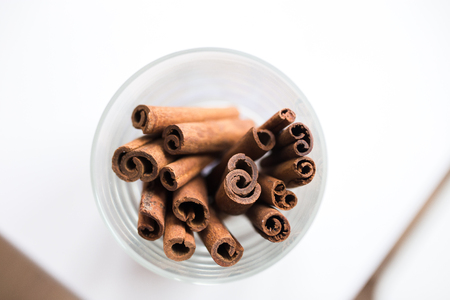 whole cinnamon on white background in a jar. twisted cinnamon in a glass  at kitchenの写真素材