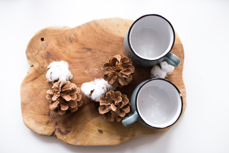 cones of spruce with a mug on a wooden board. cones lie on the background of wood, beautiful Christmas composition in the kitchenの写真素材