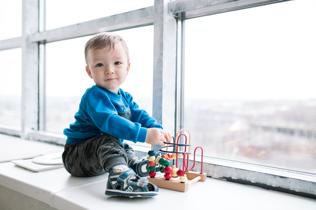 the little boy is playing in the designer. children's games at home. intellectual development of modern children. problems of raising small boys happy lifeの写真素材