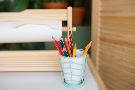 colored pencils in a glass. children's creativity, objects for design. bright pencils on the tableの写真素材