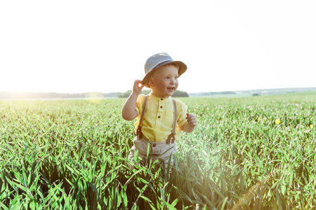 Solar photo of a boy on the field. small boy in a village playing in the grass and smileの写真素材