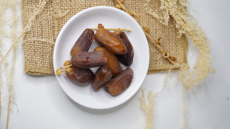 Dates fruit in a bowl on a white background. Top view.